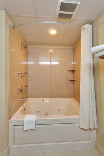 Das Bad ist mit einer Badewanne und einer Dusche ausgestattet. in der Unterkunft Country Suites Absecon-Atlantic City, NJ in Galloway