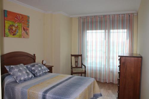 un dormitorio con una cama y una ventana en H&V Codesal, en Sanxenxo