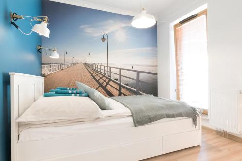 グディニャにあるBlue Apartment in vibrant heart of Gdyniaのベッドルーム(白いベッド1台、桟橋付)
