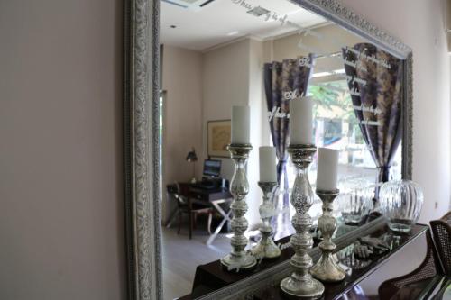a mirror on a table with candlesticks and candles at Esperia Boutique Hotel in Agrinion