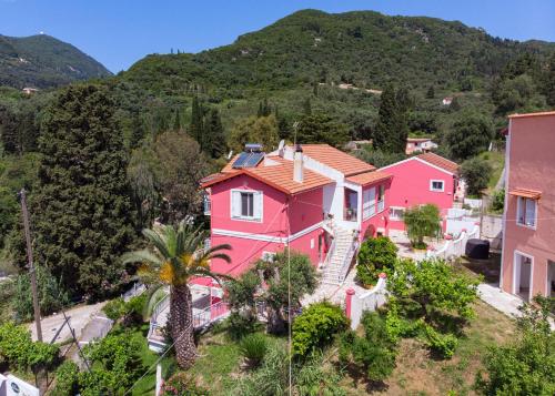 uma vista aérea de uma casa cor-de-rosa com uma palmeira em Skevoulis Studios em Benitses