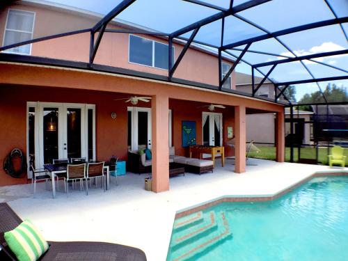 a house with a swimming pool next to a house at Aquamarine Hideaway in Kissimmee