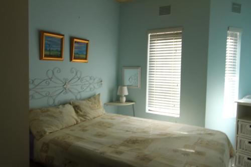 ein Schlafzimmer mit einem großen Bett und zwei Fenstern in der Unterkunft Seeskulp 10 in Margate