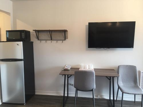 a room with a table and a refrigerator and a television at Elect Inn 5 in Cornwall