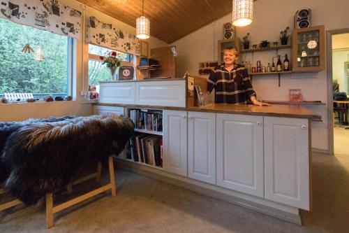 Una mujer parada en un mostrador en una cocina en Gesthus Selfoss, en Selfoss