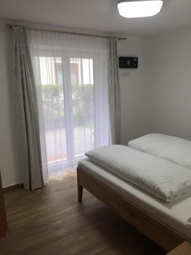 sypialnia z łóżkiem i dużym oknem w obiekcie Ferienwohnung Imbach w Kaprunie