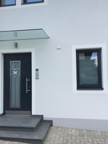 a black door on the side of a white building at Ferienwohnung Imbach in Kaprun