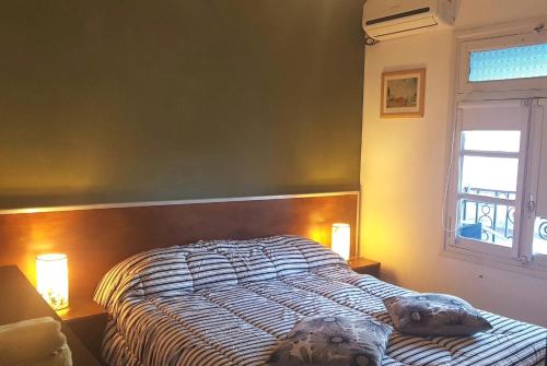 a bed in a bedroom with two lights on at Hostel Carlos Gardel in Buenos Aires