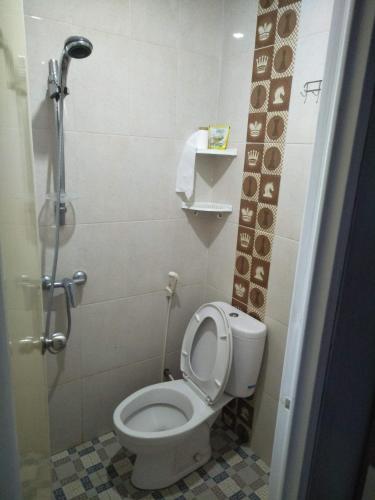 a bathroom with a toilet with the lid up at Titan's Greenhouse in Banyuwangi