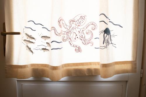 a curtain with an octopus and fish on it at Nel verde del Villaggio - Casetta Celeste in Gonnesa