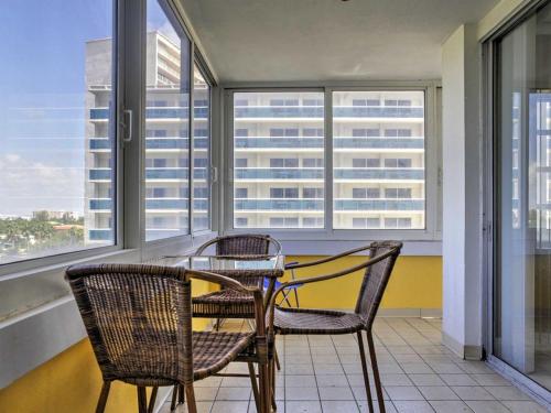 a table and chairs in a room with windows at Oceanview on SAND located in Ocean Manor Resort Fort Lauderdale Beach 2 bed 2 bath spacious corner unit partial ocean view in Fort Lauderdale