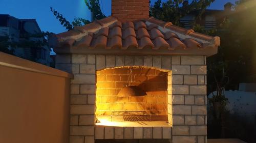 un horno de ladrillo al aire libre con techo en Apartmani Lucija, en Zadar