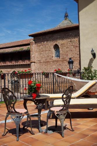 a table and two chairs and a bench on a patio at Palacio Azcárate Hotel in Ezcaray