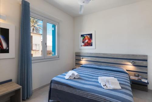 una camera da letto con un letto con asciugamani sopra di Reef and Dream a San Vito lo Capo