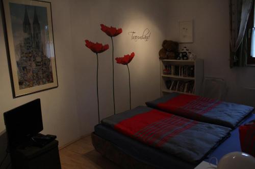 a bedroom with three red flowers on the wall at Dachstein in Russbach am Pass Gschütt