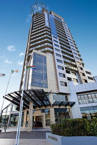 un edificio alto con una bandera delante en The Spencer Hotel, en Auckland