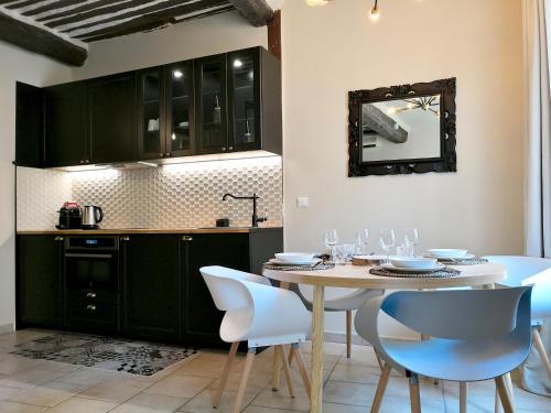 - une cuisine avec une table, des chaises blanches et un miroir dans l'établissement Little Star, à Antibes