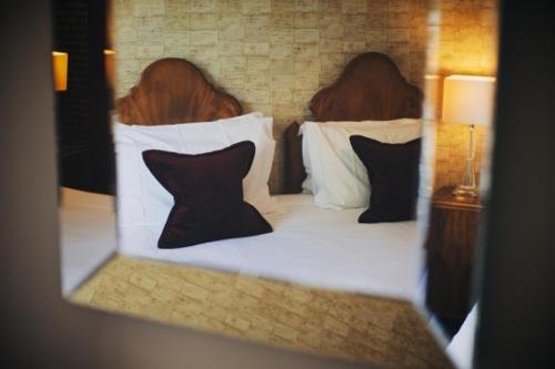 two people sitting on a bed with pillows at Rum Doodle, Windermere B&B in Windermere