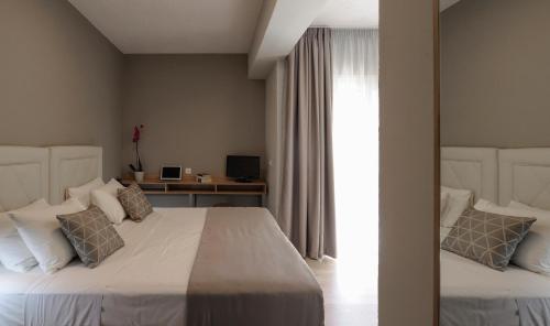 a bedroom with two beds and a desk at Skianthion in Skiathos Town