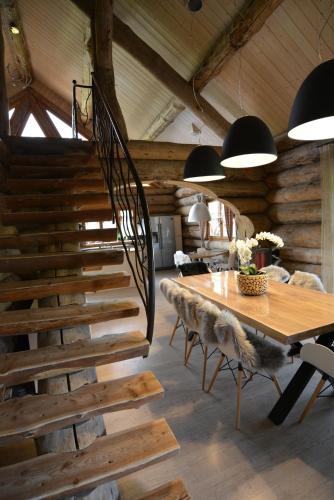 a dining room with a wooden table and a staircase at Le Chalet de Lyne in Erckartswiller