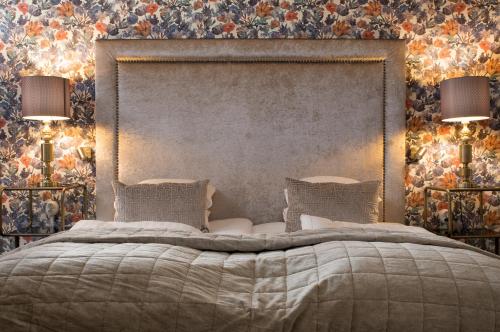 a bedroom with a large bed with two lamps at Statt Hassleholm BW Signature Collection in Hässleholm