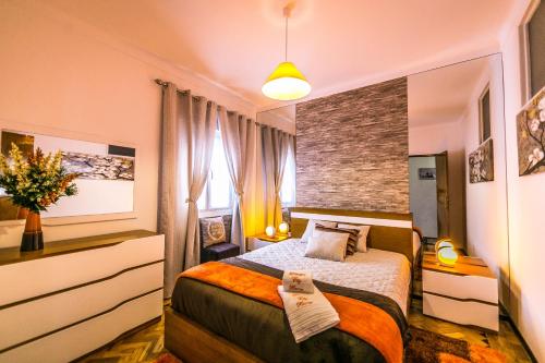 1 dormitorio con cama y pared de ladrillo en Dream city home 2, en Caldas da Rainha