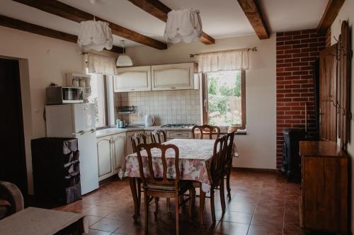 eine Küche mit einem Tisch und Stühlen sowie einem Kühlschrank in der Unterkunft Domek wypoczynkowy Piotr in Stegna