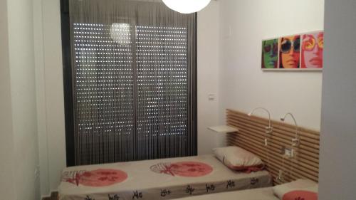サン・ホルヘにあるGolf Mar Panoramic Sant Jordiのベッド1台と大きな窓が備わる客室です。