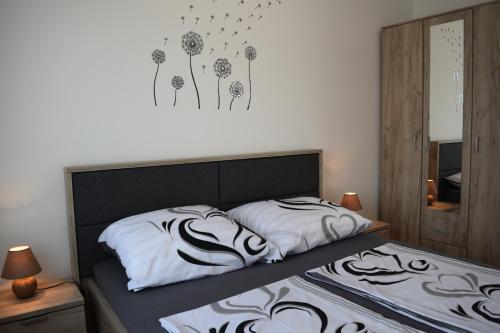 a bedroom with two beds with white sheets and flowers on the wall at Kristina Apartments in Tivat