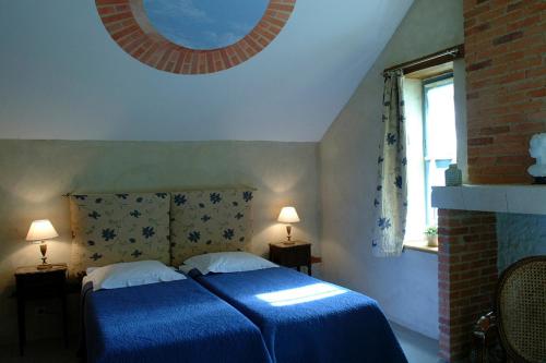 a bedroom with a bed with a blue blanket at Chambres d'Hôtes Le Clos des 3 Rois in Thouarcé