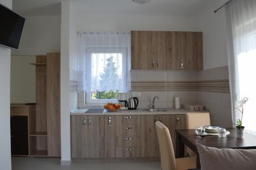 a kitchen with wooden cabinets and a table and a window at Kristina Apartments in Tivat