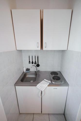 a small kitchen with a sink and a stove at Apartments Floras in Tkon