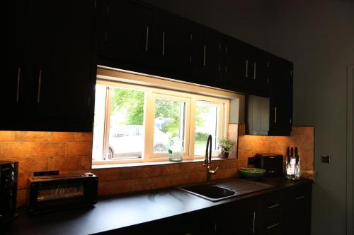 a kitchen with a sink and a window over a counter at Cuilcagh Luxury Studio in Enniskillen