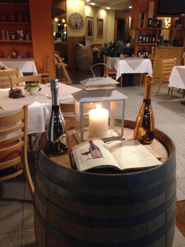 a table with two bottles of wine and a candle at Hotel Concordia in Porlezza