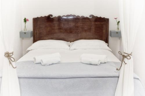 un letto bianco con lenzuola e cuscini bianchi di Dimora Zafferano - Guest House Ostuni a Ostuni
