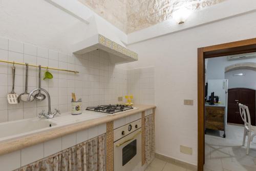una cucina con piano cottura forno superiore accanto a un lavandino di Dimora Zafferano - Guest House Ostuni a Ostuni