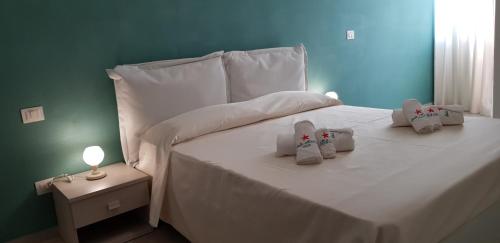 a white bed with two stuffed animals on it at Stella Marina Agropoli in Agropoli