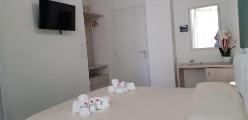 a white room with a bed with little shoes on it at Stella Marina Agropoli in Agropoli