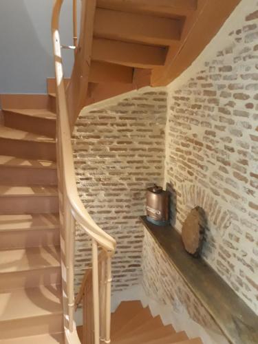 een trap in een kamer met een bakstenen muur bij Gite d'Emilie - Cahors Centre Ville avec Garage - 3 étoiles in Cahors