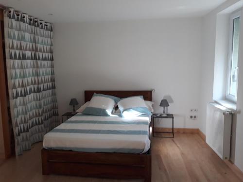 ein Schlafzimmer mit einem Bett mit zwei Kissen in der Unterkunft Gite d'Emilie - Cahors Centre Ville avec Garage - 3 étoiles in Cahors