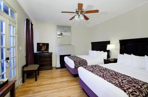 ein Hotelzimmer mit 2 Betten und einem Deckenventilator in der Unterkunft Inn on Ursulines, a French Quarter Guest Houses Property in New Orleans