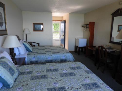 a hotel room with two beds and a desk at Admiral Digby Inn Restaurant and Cottages in Digby