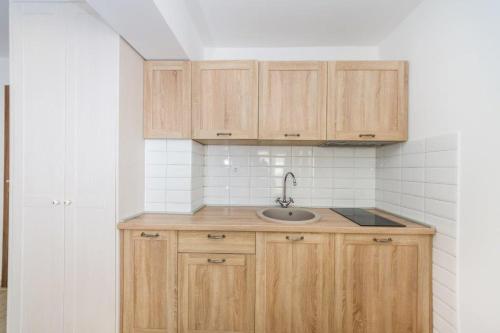 a kitchen with wooden cabinets and a sink at Apartmani Paradise in Petrcane