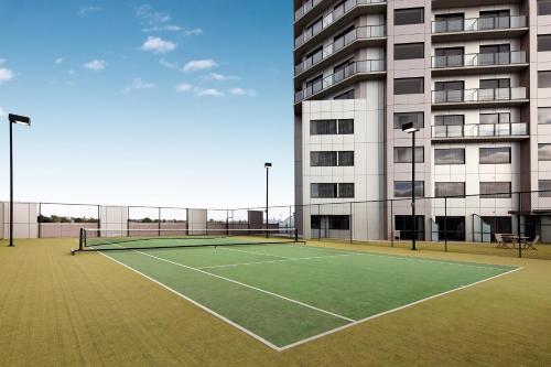 una cancha de tenis frente a un edificio en The Spencer Hotel, en Auckland