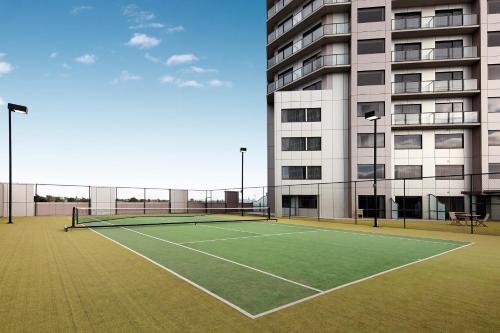 a tennis court in front of a building at The Spencer Hotel in Auckland