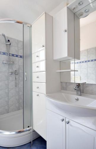 a white bathroom with a sink and a shower at Suitable Summer Apartments in Pula