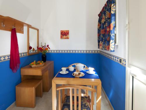 uma sala de jantar com paredes azuis e uma mesa e cadeiras em Villaggio Albergo Internazionale La Plaja em Catânia