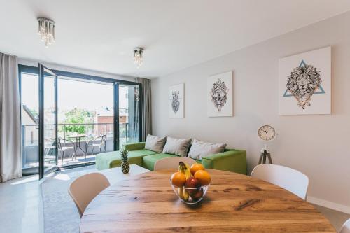 una sala de estar con una mesa de madera con fruta. en Eight - Luxury Apartment with Beautiful View, en Cracovia