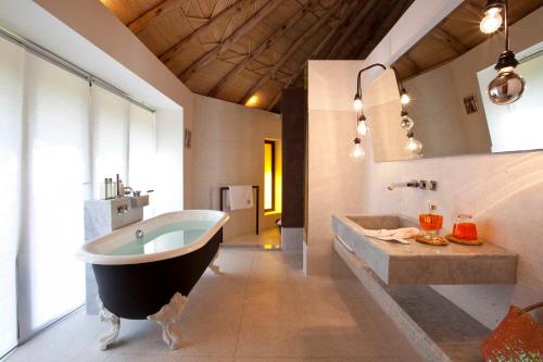 ein großes Bad mit einer großen Badewanne und einem Waschbecken in der Unterkunft Hotel Les Cinq Djellabas in Douar Caïd Layadi