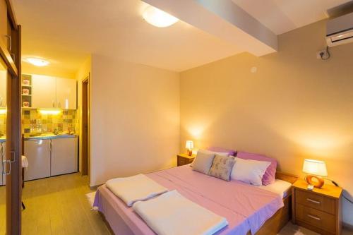 a bedroom with a large bed and a kitchen at Fresh & spacious studio in Dubrovnik